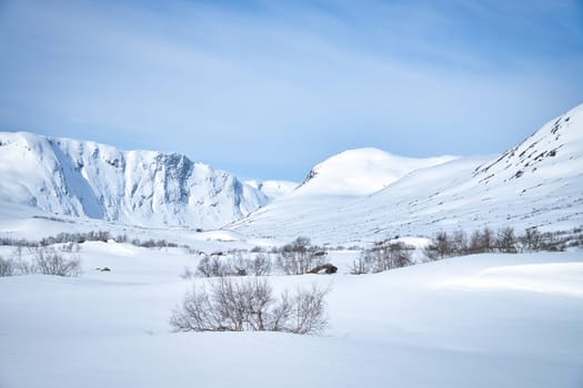 Norwegian high mountains in the snow. Mountains covered in snow. Scandinavian landscape in the far north