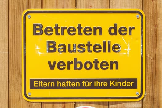 Yellow sign No trespassing on a construction site, Germany