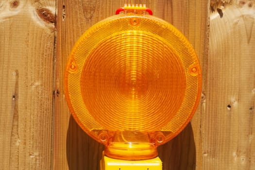 Orange construction site lamp on a site fence, Germany