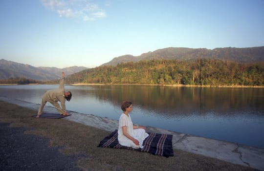 People at a Yoga cless at the Holy Ganges River in the city of Rishikesh in the Province Uttarakhand in India.  India, Rishikesh, February, 1998