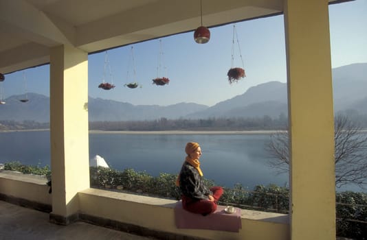 People at a Yoga class at the Holy Ganges River in the city of Rishikesh in the Province Uttarakhand in India.  India, Rishikesh, February, 1998