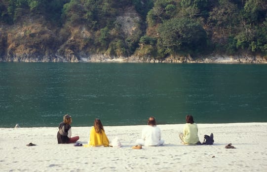 People at a Yoga class at the Holy Ganges River in the city of Rishikesh in the Province Uttarakhand in India.  India, Rishikesh, February, 1998