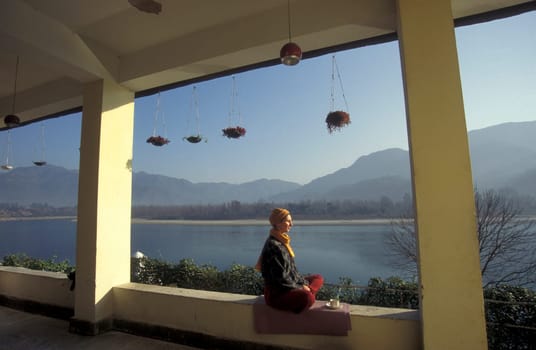 People at a Yoga class at the Holy Ganges River in the city of Rishikesh in the Province Uttarakhand in India.  India, Rishikesh, February, 1998