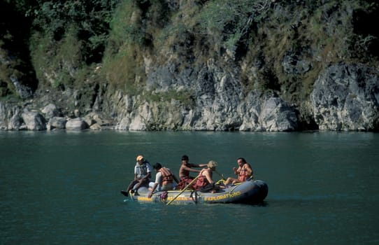 a river rafting Boat on the Holy Ganges River with the city of Rishikesh in the Province Uttarakhand in India.  India, Rishikesh, February, 1998