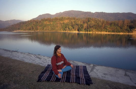 People at a Yoga class at the Holy Ganges River in the city of Rishikesh in the Province Uttarakhand in India.  India, Rishikesh, February, 1998