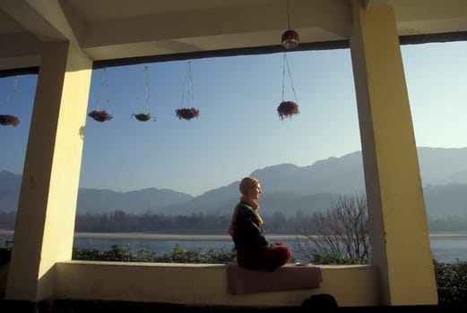 People at a Yoga class at the Holy Ganges River in the city of Rishikesh in the Province Uttarakhand in India.  India, Rishikesh, February, 1998
