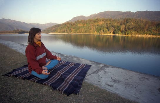 People at a Yoga class at the Holy Ganges River in the city of Rishikesh in the Province Uttarakhand in India.  India, Rishikesh, February, 1998