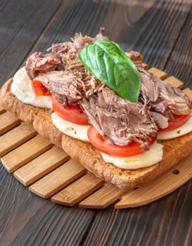 Sandwich with pulled pork, tomato, mozzarella and basil
