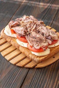 Sandwich with pulled pork, tomato, mozzarella and basil