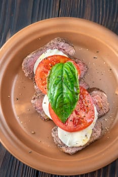 Caprese rib eye steak with mozzarella, tomato and basil
