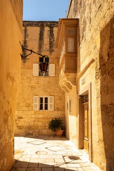 Traditional Maltese house lining narrow streets in silent city Mdina, adorned with colorful doors and flowers, capturing the essence of local architecture and culture. Malta travel destination.