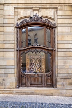 A storefront with an ornate wooden window, displaying a patterned rug in Old Town, aka Icherisheher, in Baku, Azerbaijan
