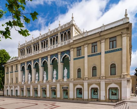 Nizami Museum of Azerbaijan, with statues lining the facade. The building is decorated with arches and intricate tile work, located in Baku near the famous Nizami Street
