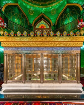 The ornate, golden-trimmed tomb of Ukeyma Khanum, a prominent figure in Azerbaijan's history, is enclosed in a latticework enclosure within the Bibi-Heybat Mosque in Baku