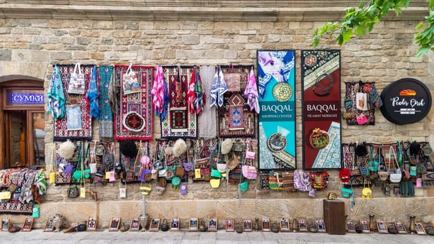 Baku, Azerbaijan - May 4 2024: A shop in the historic Icherisheher district of Baku, showcasing colorful woven rugs, bags, and other traditional goods for sale