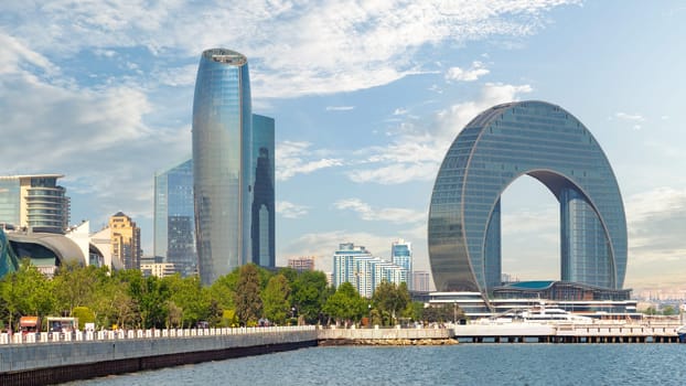 Baku, Azerbaijan - May 10, 2024: The Crescent Development Project features modern architecture, including the Crescent Hotel, against clear sky on the Baku Boulevard by the Caspian Sea coast