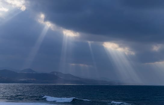 Beautiful sunrays on the Atlantic coast in Las Palmas de Gran Canaria, view from Las Canteras beach