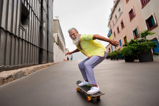 Elderly man in glasses with gray hair and beard skateboarding on urban street, enjoying life.