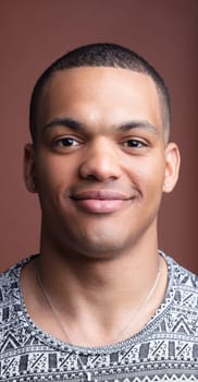 Young man smiles confidently in a stylish studio portrait, radiating happiness and positivity with trendy fashion and modern style