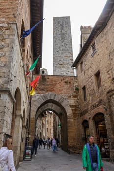 San Gimignano, Italy - Sept 17, 2022: Tourists on Via San Mateo in the medieval town of San Gimingnano. Tuscany, Italy