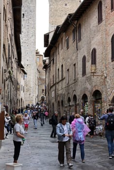 San Gimignano, Italy - Sept 17, 2022: Crowds of tourists on Via San Giovanni in the medieval town of San Gimingnano. Tuscany, Italy