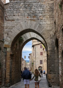 San Gimignano, Italy - Sept 17, 2022: Tourists on Via San Mateo in the medieval town of San Gimingnano. Tuscany, Italy