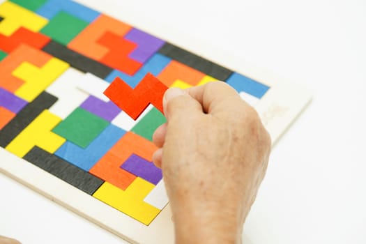 Asian elderly woman playing puzzles game for treatment dementia prevention and Alzheimer disease.