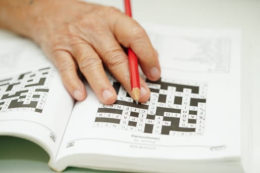 elderly woman playing sudoku puzzle game for treatment dementia prevention and Alzheimer disease.