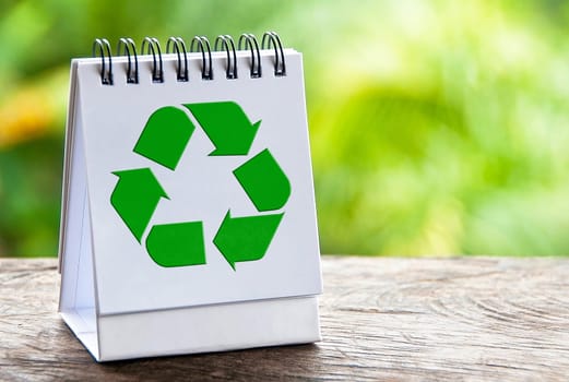 Recycle symbol on with notepad with blur nature background. Recycle concept.