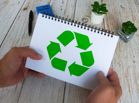 Recycle symbol on white notebook. Reuse, reduce and recycle.