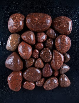 Wet black stones on a dark background