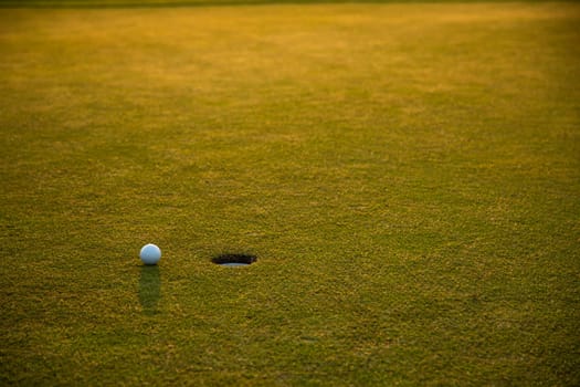 Golf ball and clubs in golf field