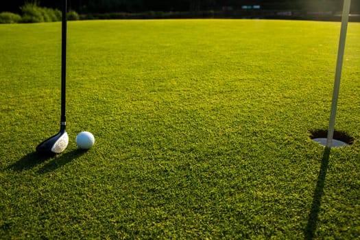 Golf player playing in a golf club on a beautiful sunset in the evening
