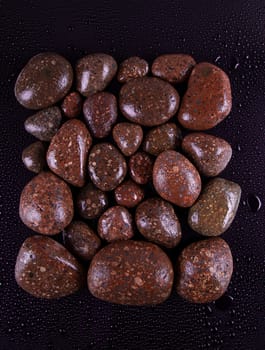 Wet black stones on a dark background