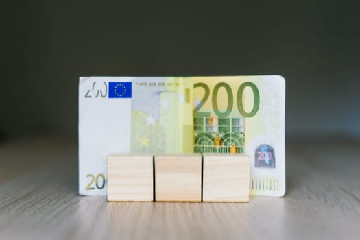 Wooden cubes blocks, money 200 Euro banknotes. Management big salary career conception