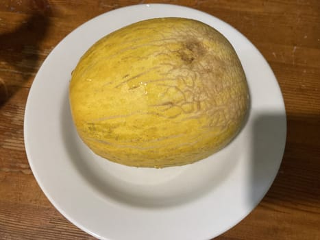 Ripe yellow melon on a the white plate