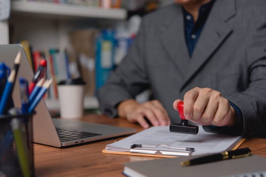 A professional applies an official seal to company documents, signifying authentication and approval.