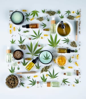 Flat lay composition with marijuana leaves, bottle of oil, cannabis on cbd, white background