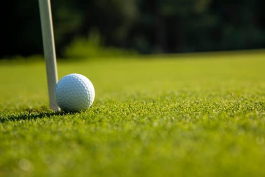 Golf ball and clubs in golf field