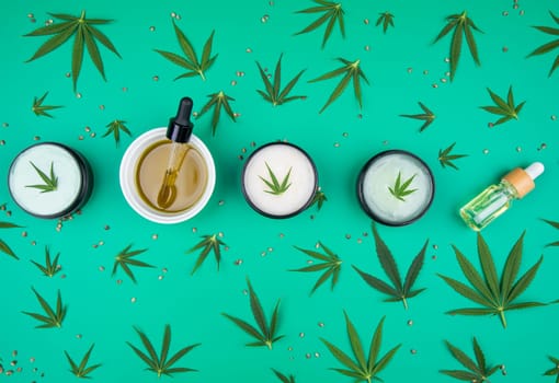 Flat lay composition of marijuana and hemp seeds on color green background