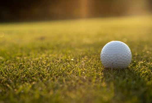 Golf ball and clubs in golf field