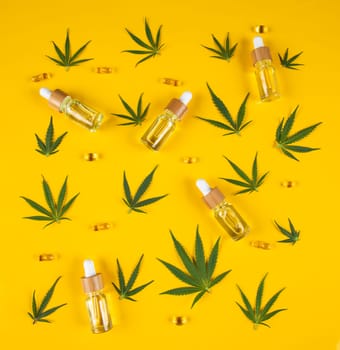 Set of cannabis oil bottles with hemp oil on yellow background. top view. flat lay