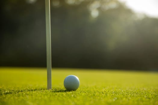 Golf ball and clubs in golf field