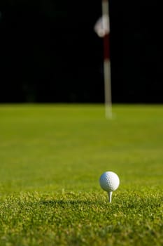 Golf ball and clubs in golf field