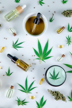Top view of marijuana leaves and cannabis buds on white background