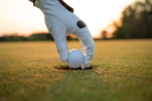 Golf course with ball and grass on close up of a hand     ,grass,golfer,golfing,sky,nature,ball,object,play,blue,fairway,closeup,club,outdoor     ,competition,recreation,background,color,summer