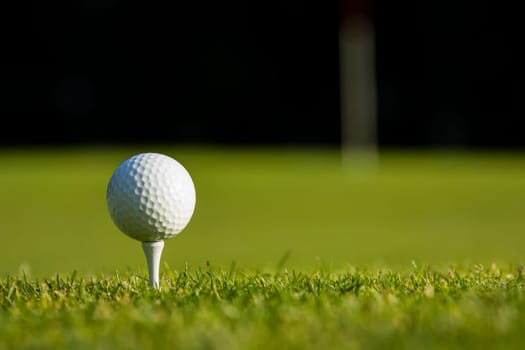 Golf ball and clubs in golf field
