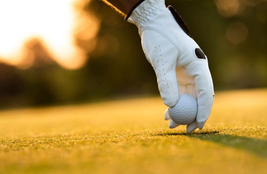 Golf course with ball and grass on close up of a hand     ,grass,golfer,golfing,sky,nature,ball,object,play,blue,fairway,closeup,club,outdoor     ,competition,recreation,background,color,summer