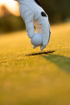 Golf course with ball and grass on close up of a hand     ,grass,golfer,golfing,sky,nature,ball,object,play,blue,fairway,closeup,club,outdoor     ,competition,recreation,background,color,summer