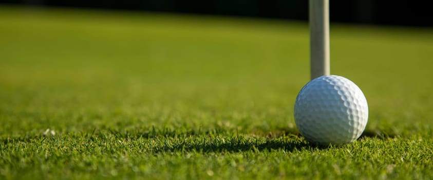 Golf ball and clubs in golf field